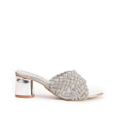 A pair of silver-colored sandals with a textured surface and block heels, featuring a two-strap sandal design.