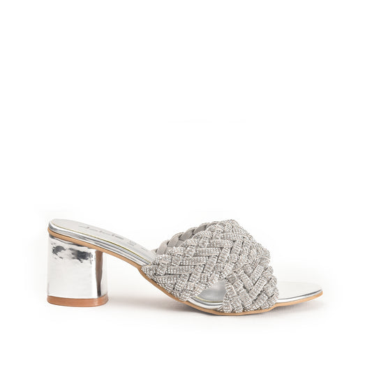 A pair of silver-colored sandals with a textured surface and block heels, featuring a two-strap sandal design.