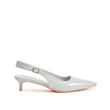A pair of white, glossy, casual style, round-toed flats with a small metallic ornament on the toe and a pencil-style strap.