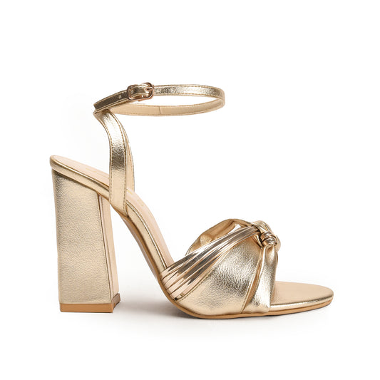 A gold-colored sandal with a block heel and an open-toe strap.