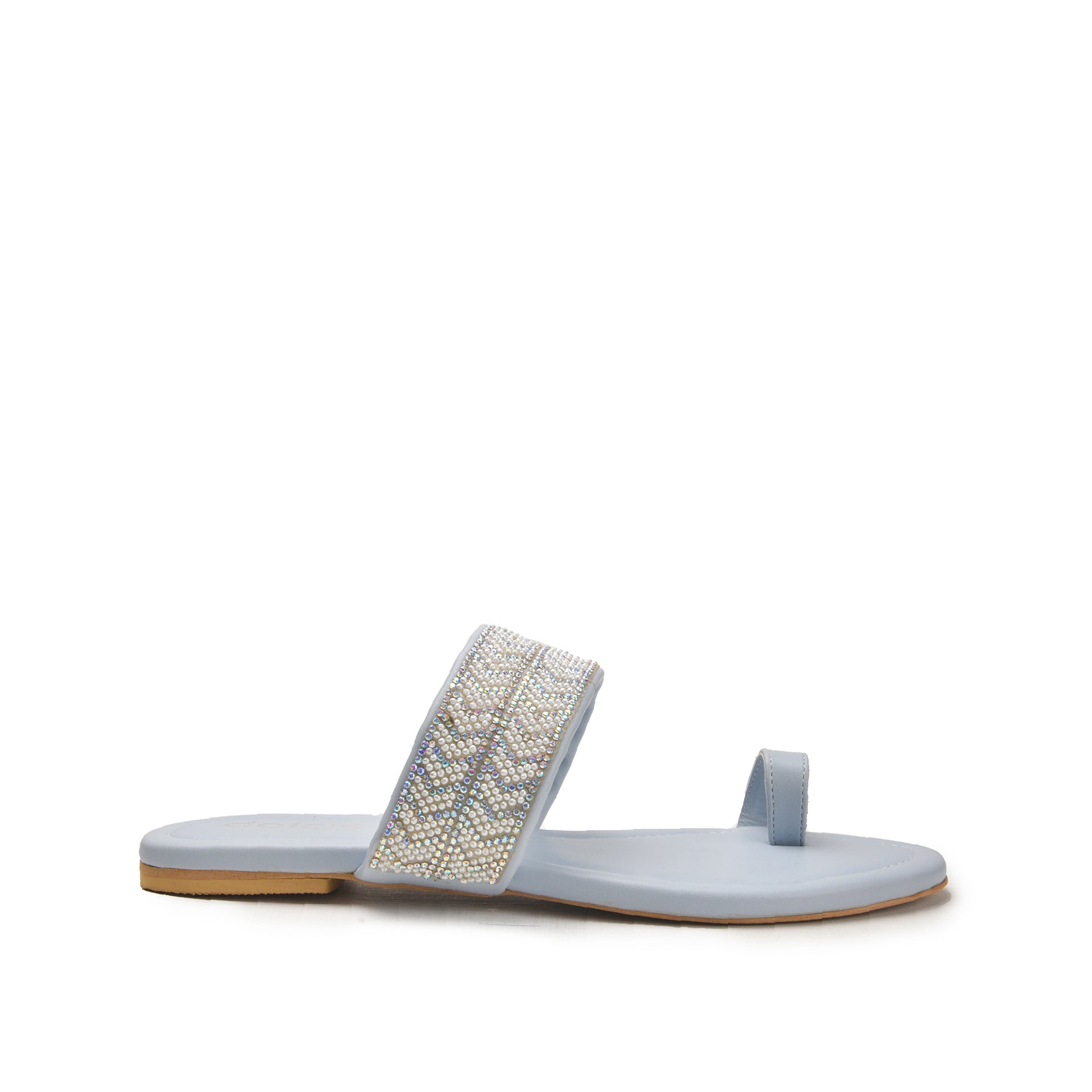 A blue slip-on slipper with a decorative metallic pattern on the sole.